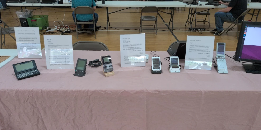 A table at the vintage computing club showing the HP 200LX, Palm III, Gameboy Color, Sony CLIÉ T-415, Sony CLIÉ T-615, and Sony CLIÉ PEG NX-70V